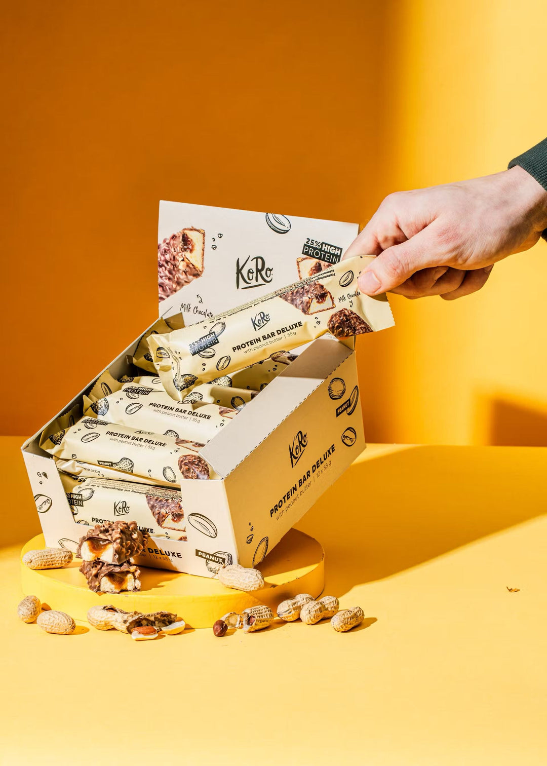 A close-up image of a KoRo Protein Bar Deluxe, weighing 55g, with nuts and seeds, perfect for a healthy snack on the go