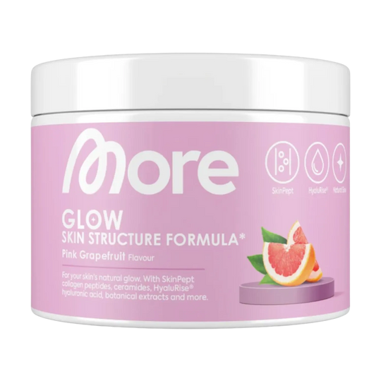 Woman-holding-a-scoop-of-More-Nutrition-Glow-Skin-Structure-Formula-powder-with-a-glass-of-water-ready-to-mix